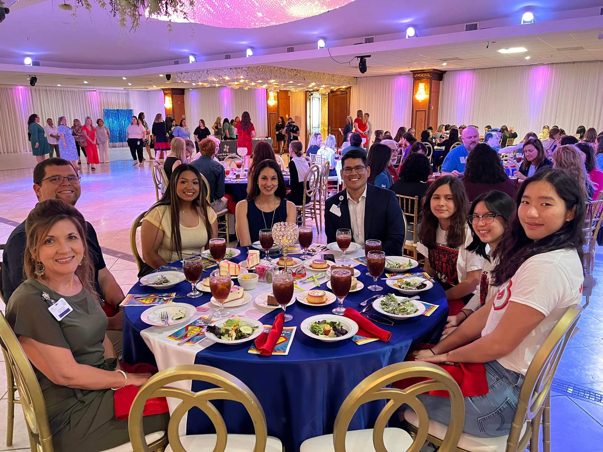 People at a table with food and drinks at an event