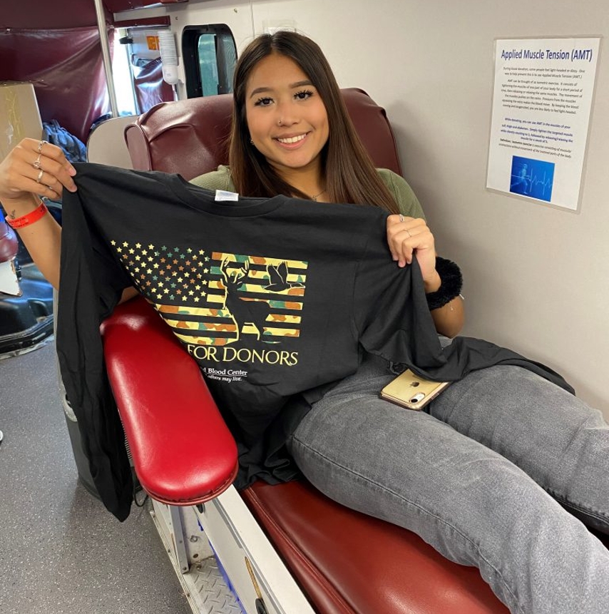 Girl holding a t-shirt after donating